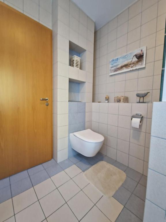 ein Bad mit einem WC und einer braunen Tür in der Unterkunft Ferienhaus Hasenhügel mit Seeblick in Schwedt