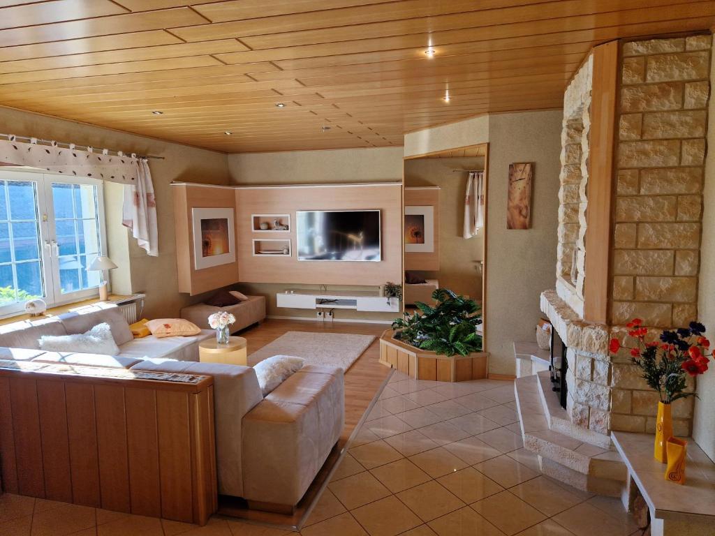 ein Wohnzimmer mit Sofa und Fernseher in der Unterkunft Ferienhaus Hasenhügel mit Seeblick in Schwedt