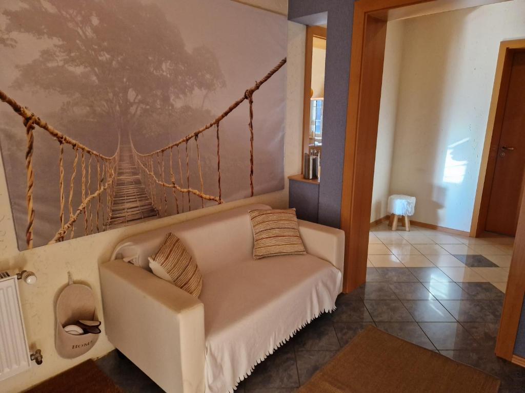 ein Wohnzimmer mit einer Couch und einer Schaukel-Wandmalerei in der Unterkunft Ferienhaus Hasenhügel mit Seeblick in Schwedt
